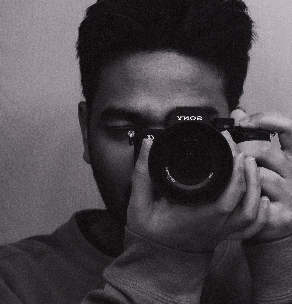 TheUploadArticleBlog.com Artistic black and white photo of a young man holding a camera.