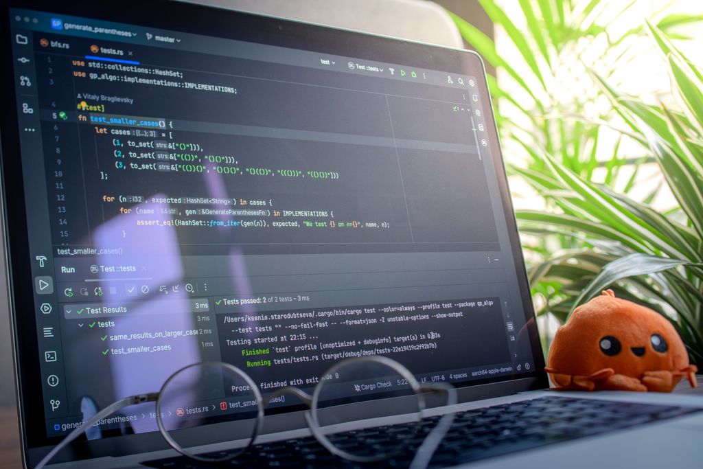 Developer Tools News Today Open laptop displaying code next to a plush toy, set in a bright room with plants.